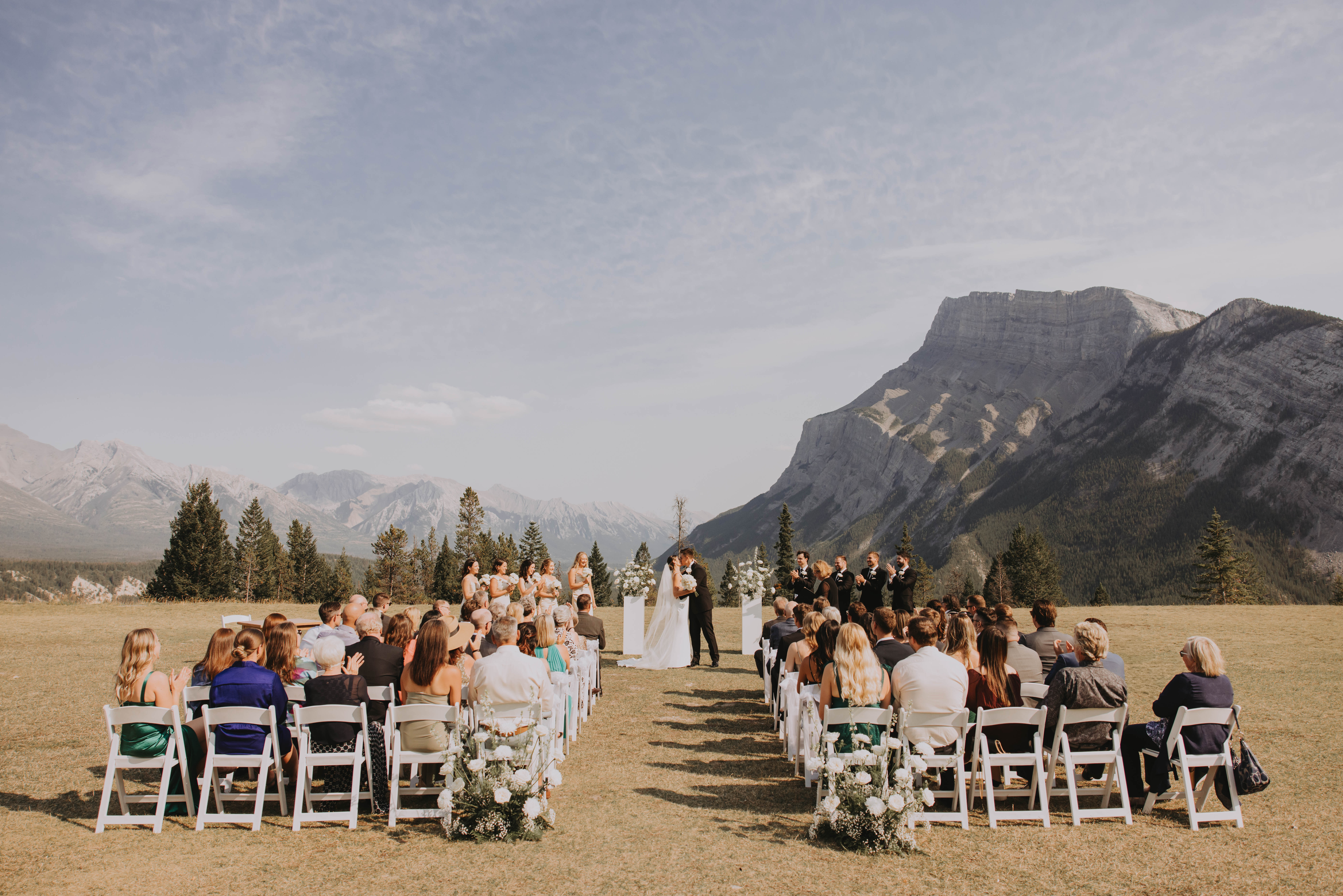 Outdoor wedding ceremony with mountain backdrop at Tunnel Mountain in Banff National Park.